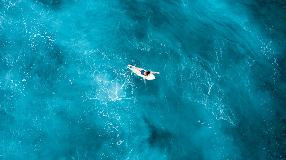 person on surfboard in midst of sea