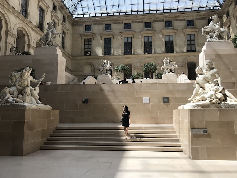 femme debout sur les escaliers devant le musée