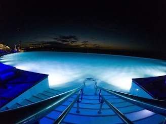 The inviting pool and jacuzzi glowing softly under evening lights.