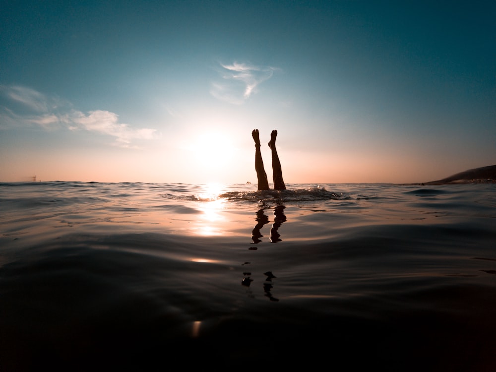 person diving in body of water