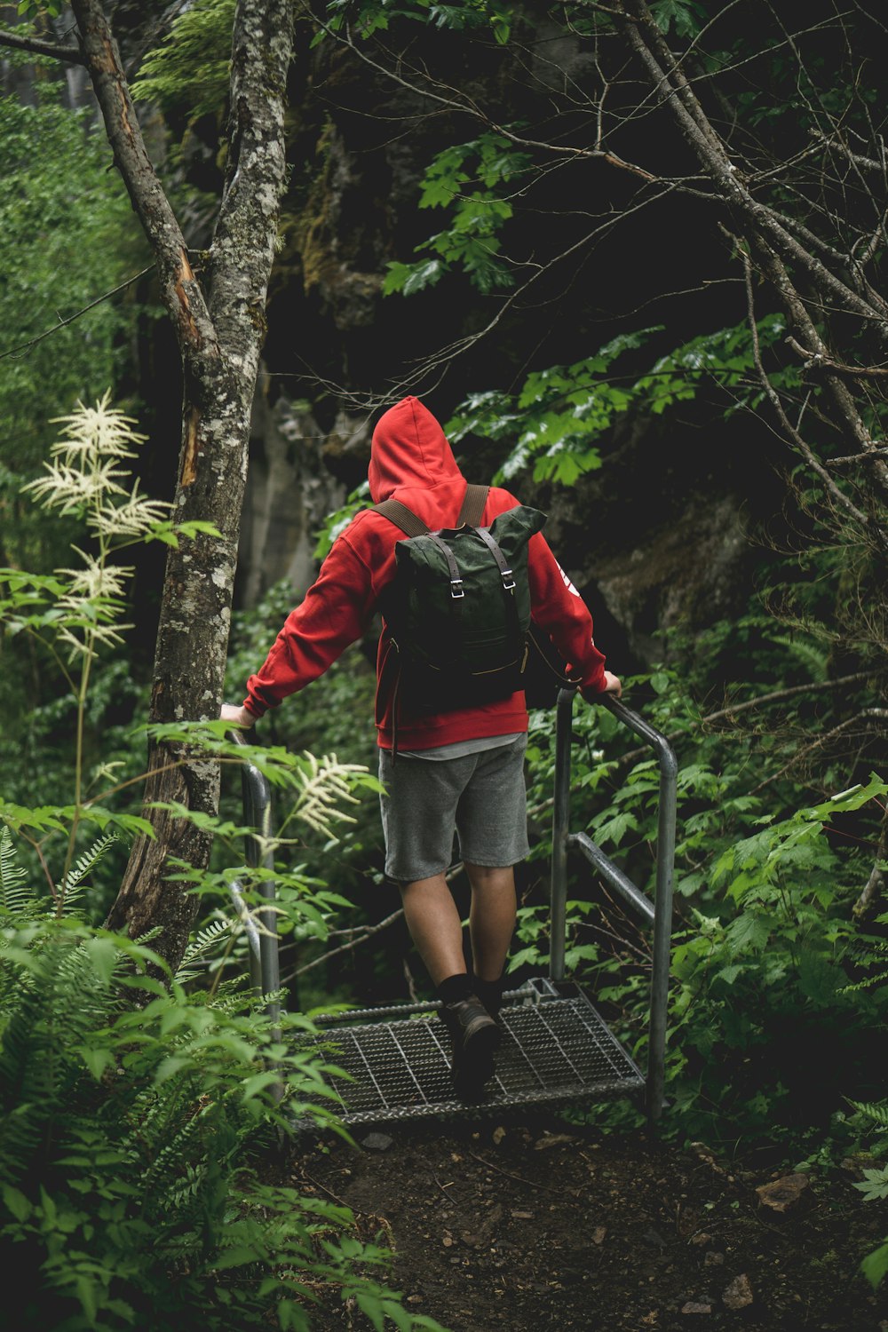 man in red and white hoodie standing on metal frame