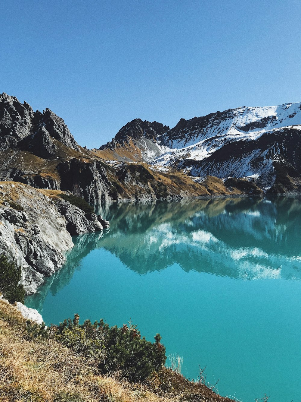 blue lake surrounded with snow capped mountains