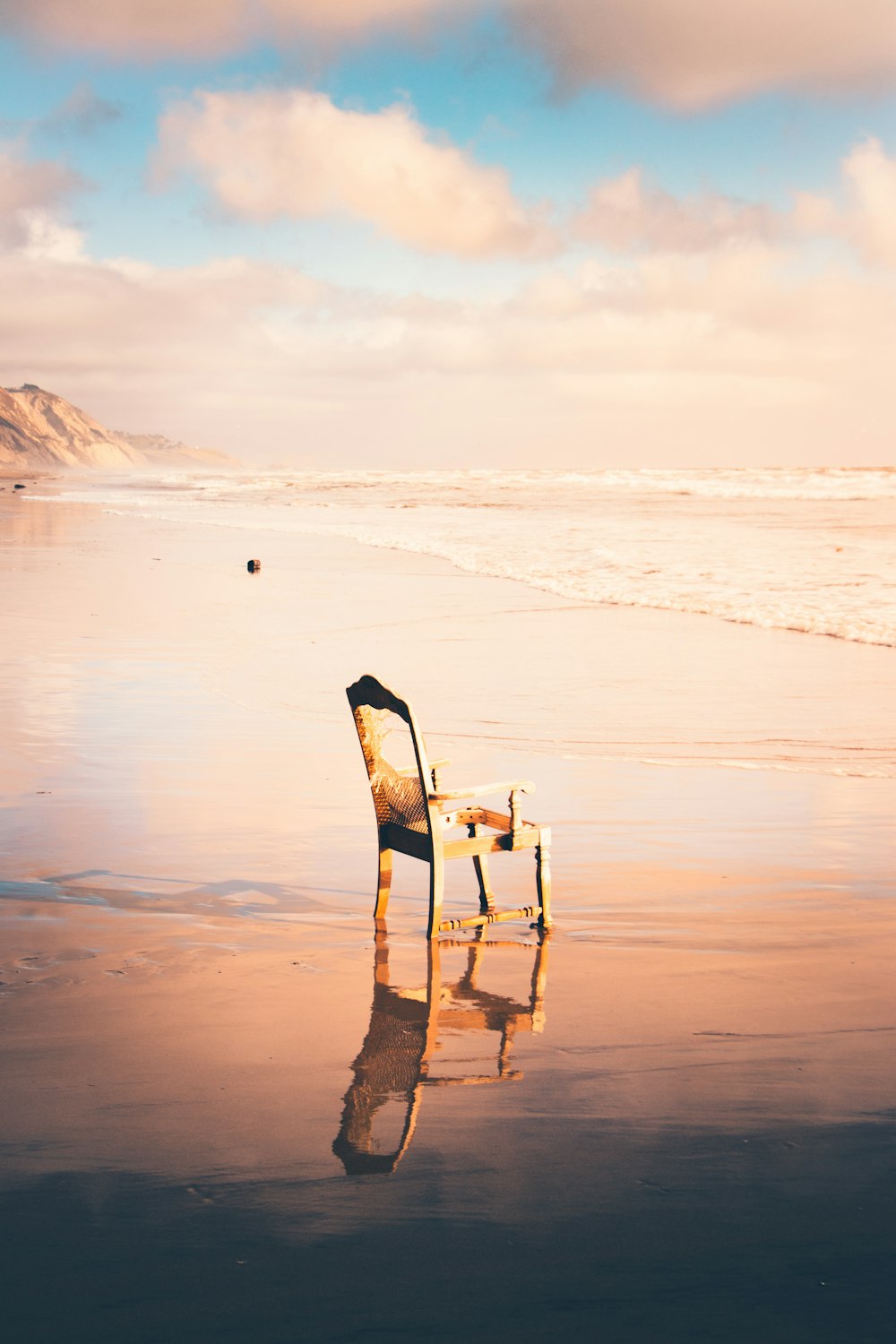brown wooden armchair near the sea at daytime