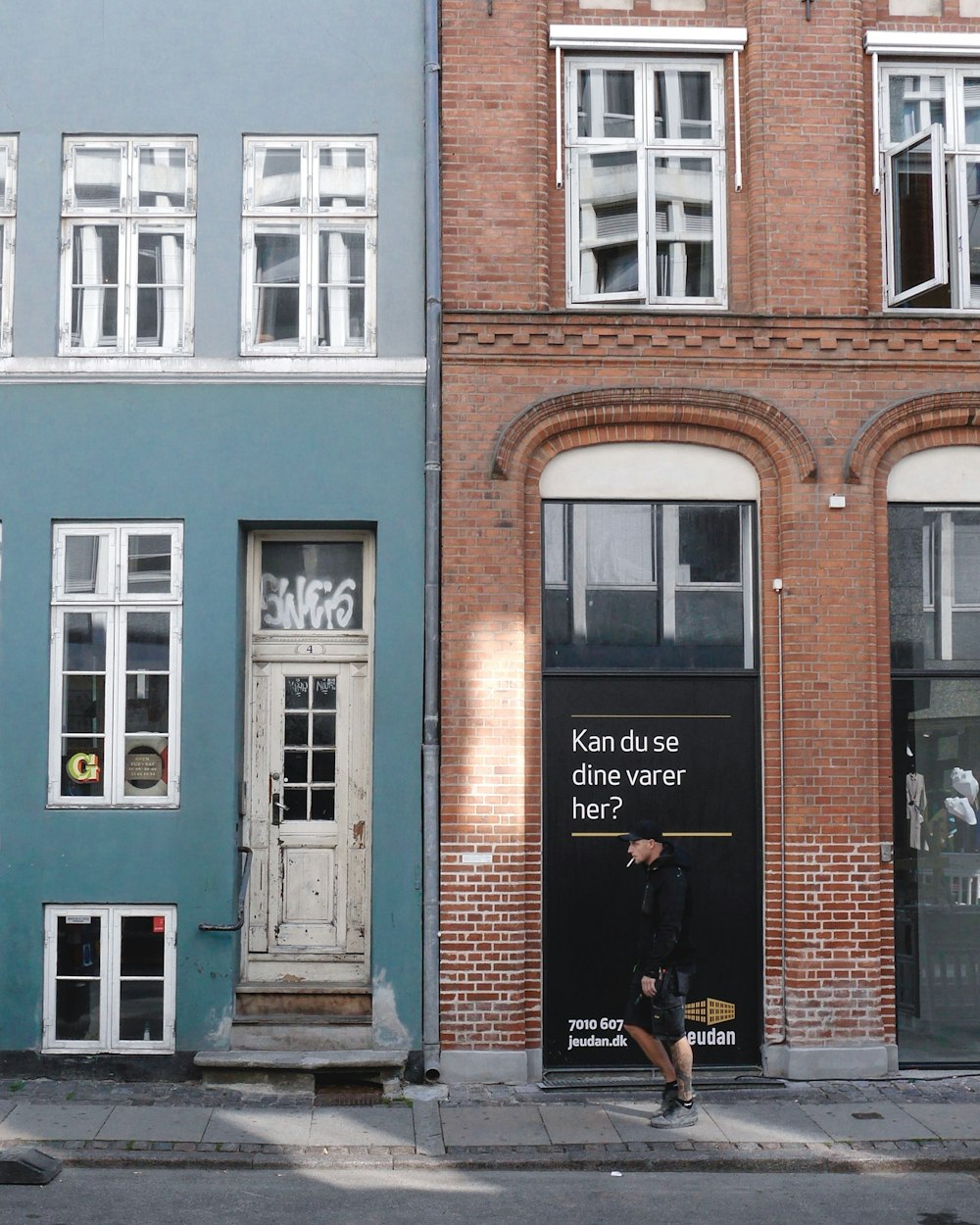 man standing infront of brown concrete building