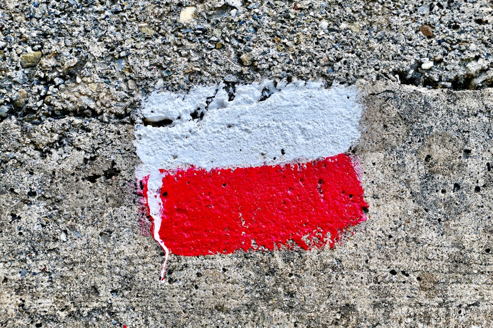 un drapeau rouge, blanc et bleu peint sur du béton