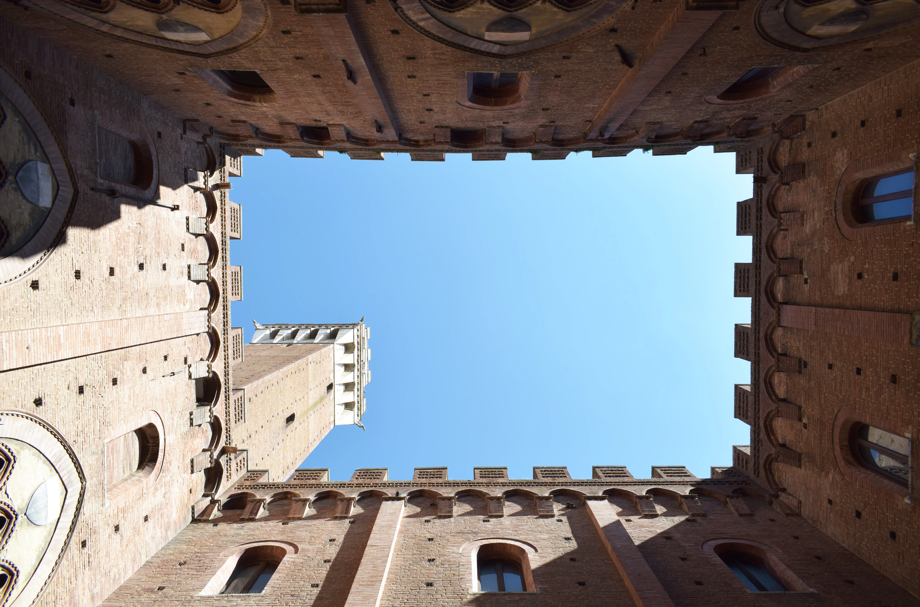 Binnenplaats van het Palazzo Pubblico met de Torre del Mangia boven de bakstenen muren