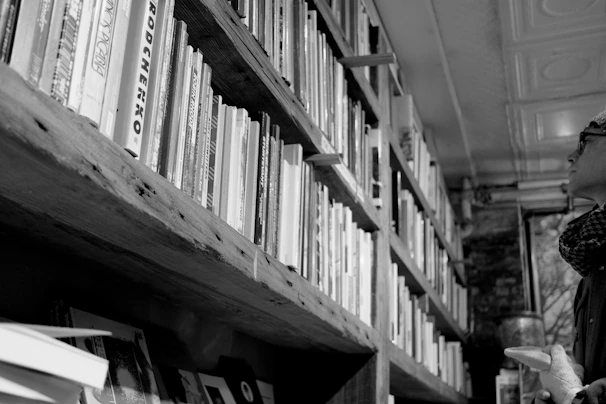 Black and white photograph of an old bookstore’s cozy interior.