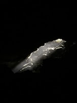 Sunlight illuminating crystalline silver deposits within a mine shaft.