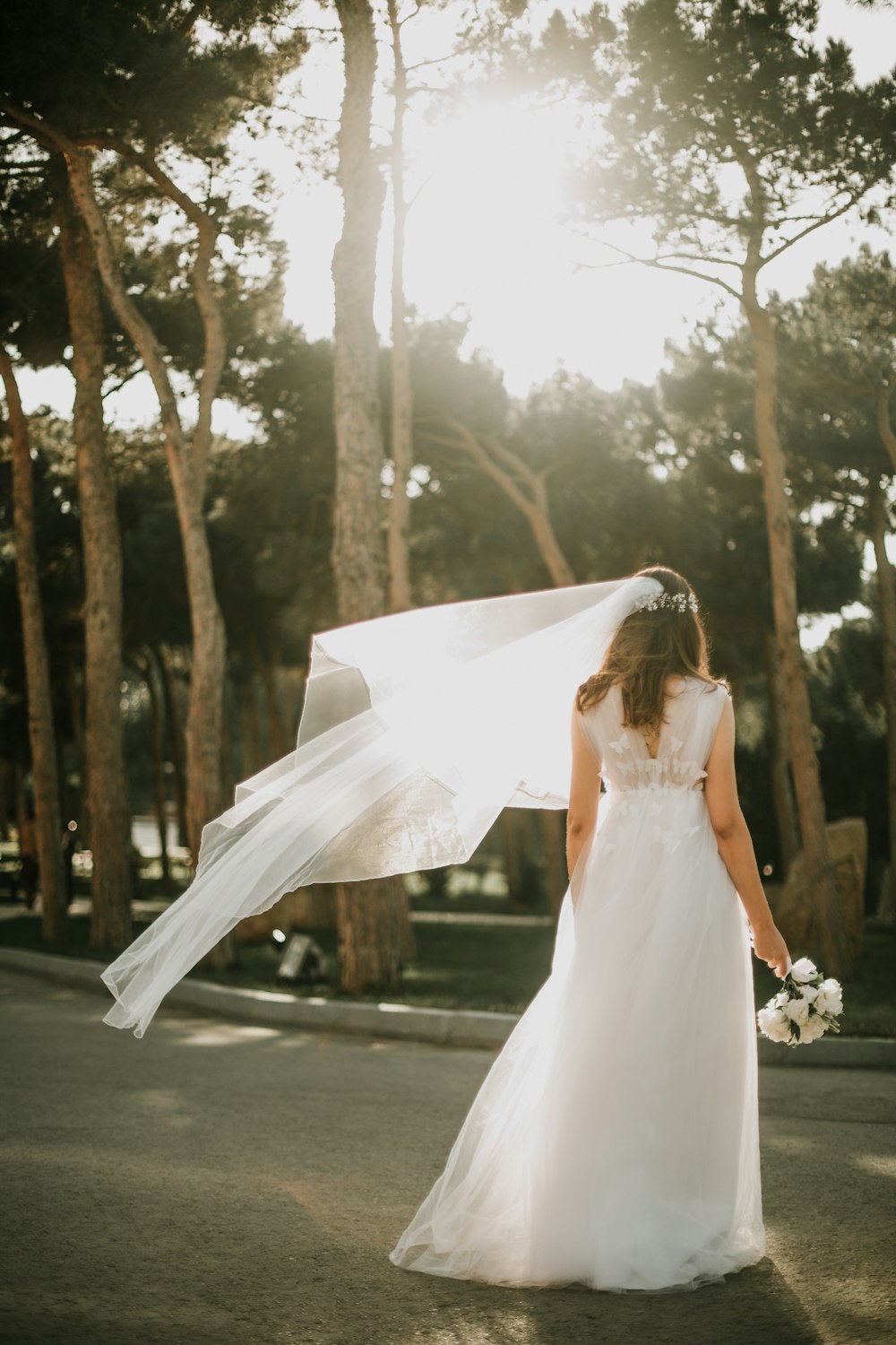 Mujer en vestido de novia blanco de pie sobre hormigón gris