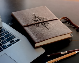 brown book beside MacBook