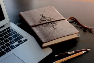 brown book beside MacBook