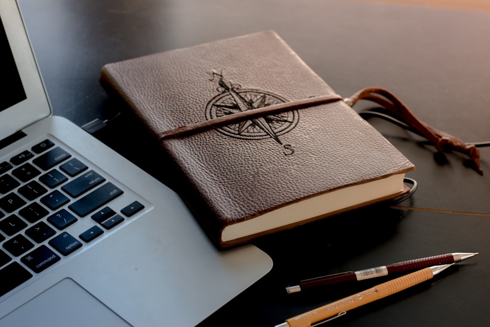 brown book beside MacBook