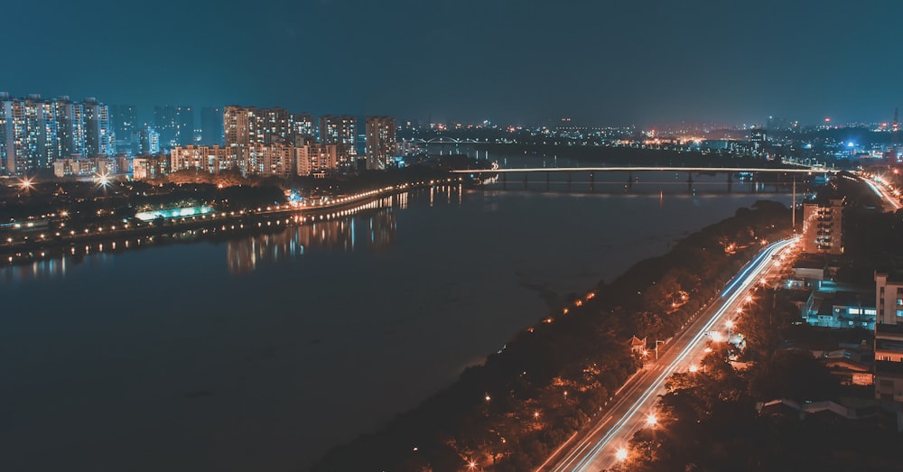 concrete road near bridge and water at nigh time