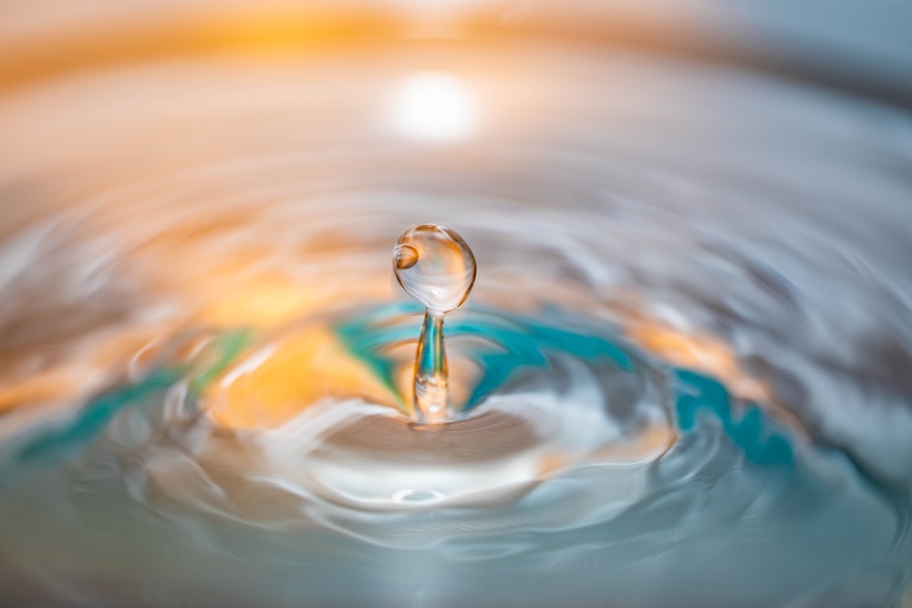 Photographie macro-objectif d’une goutte d’eau provoquant une ondulation à la surface de l’eau