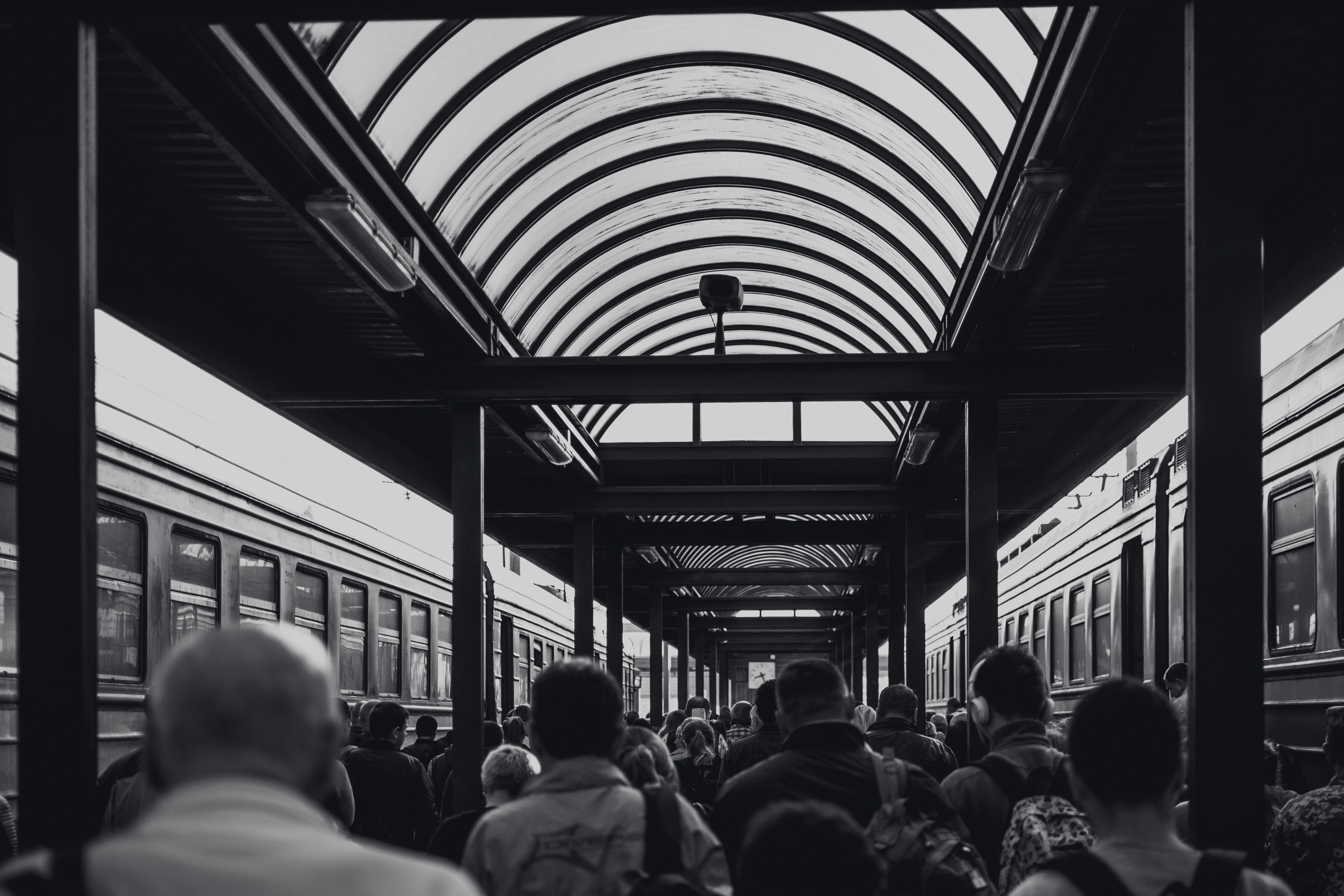 grayscale photo of people under waiting shed, 