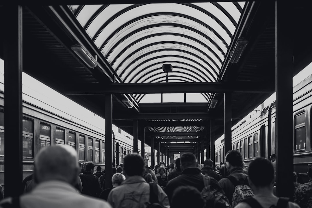 grayscale photo of people under waiting shed