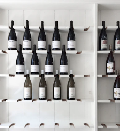 Minimalist product display of wine and agave bottles side by side on a white surface