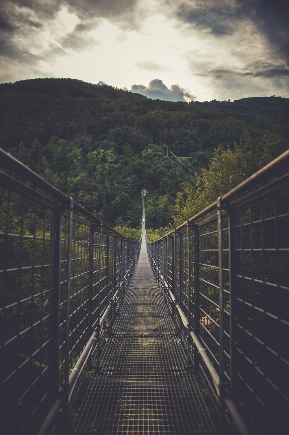 black metal mesh bridge under white sky