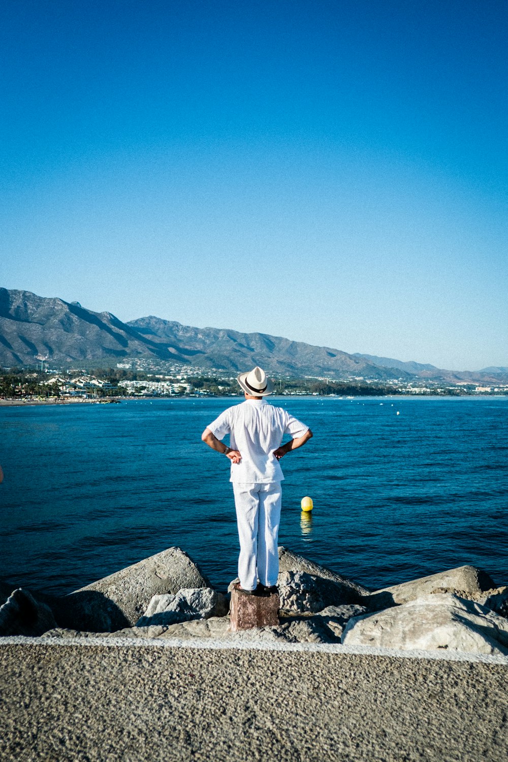 person in white top looking at the sea