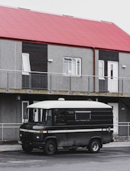A van parked in front of a modern office building.