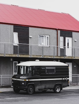 A van parked in front of a modern office building.