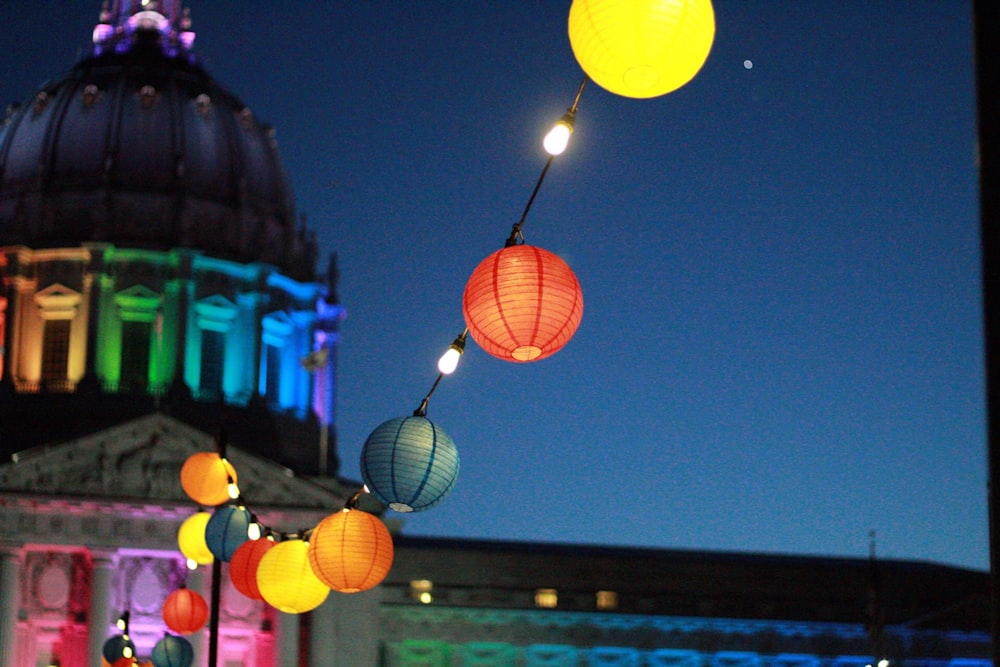 line of lighted lanterns in front of dome building during nighttime