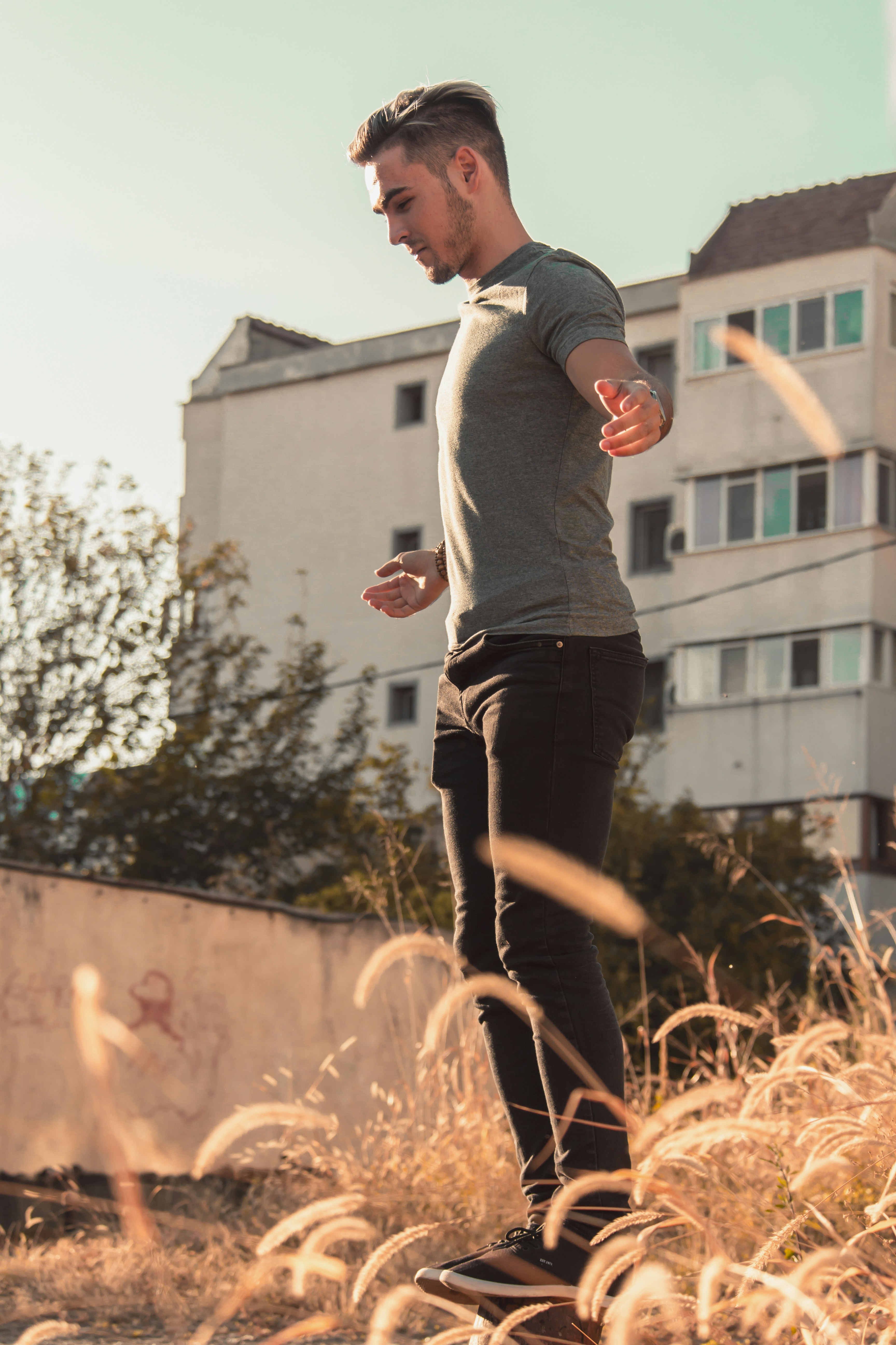 man standing on brown plants near building during daytime