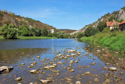 A peaceful river flowing through vibrant natural landscapes near residential lots.