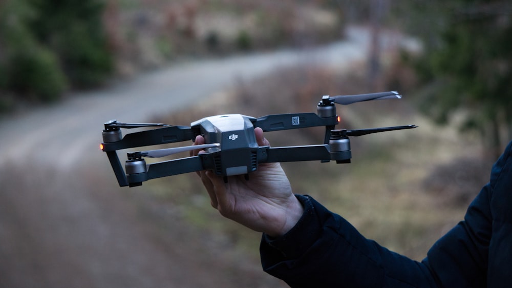 person holding black DJI drone