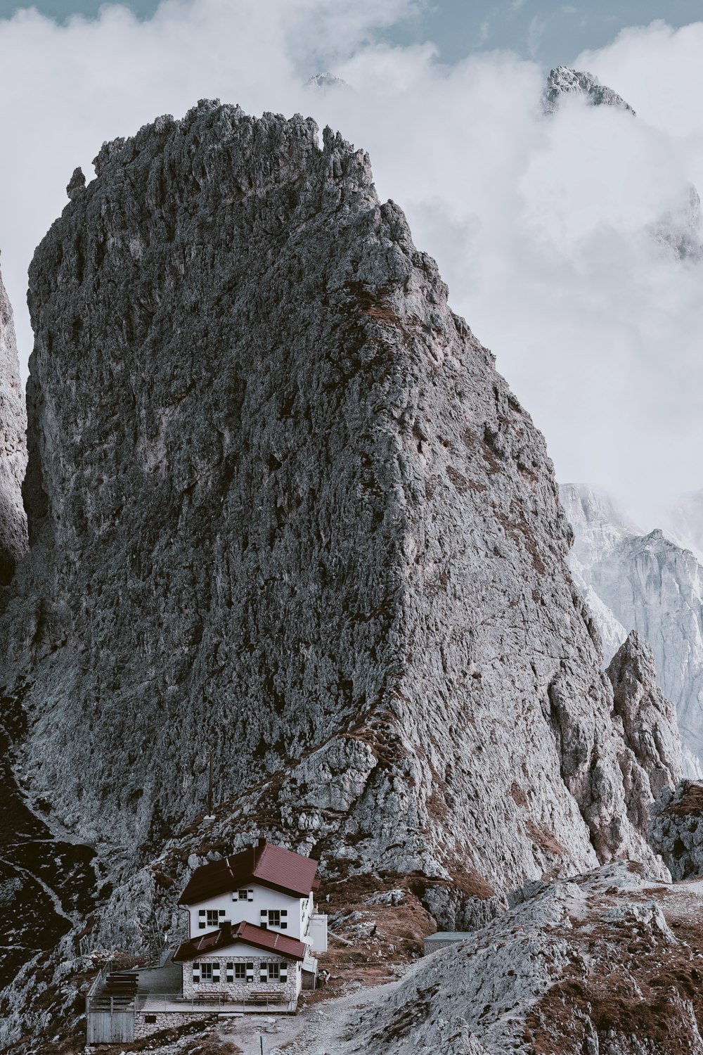 white 2-story house beside mountain cliff during daytime