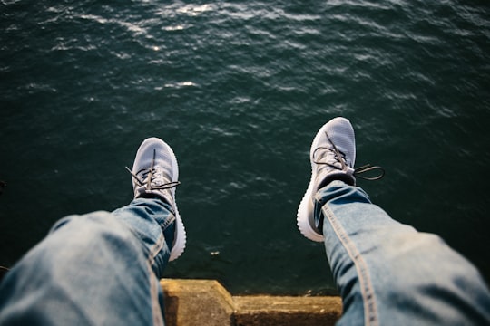 person sitting near body of water in Whitby United Kingdom