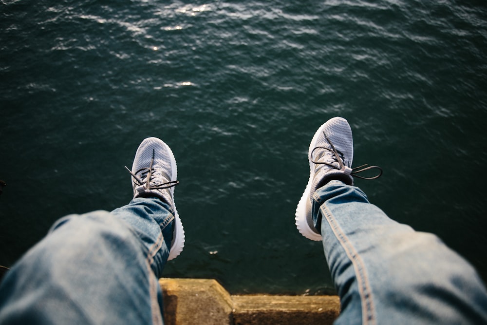 person sitting near body of water