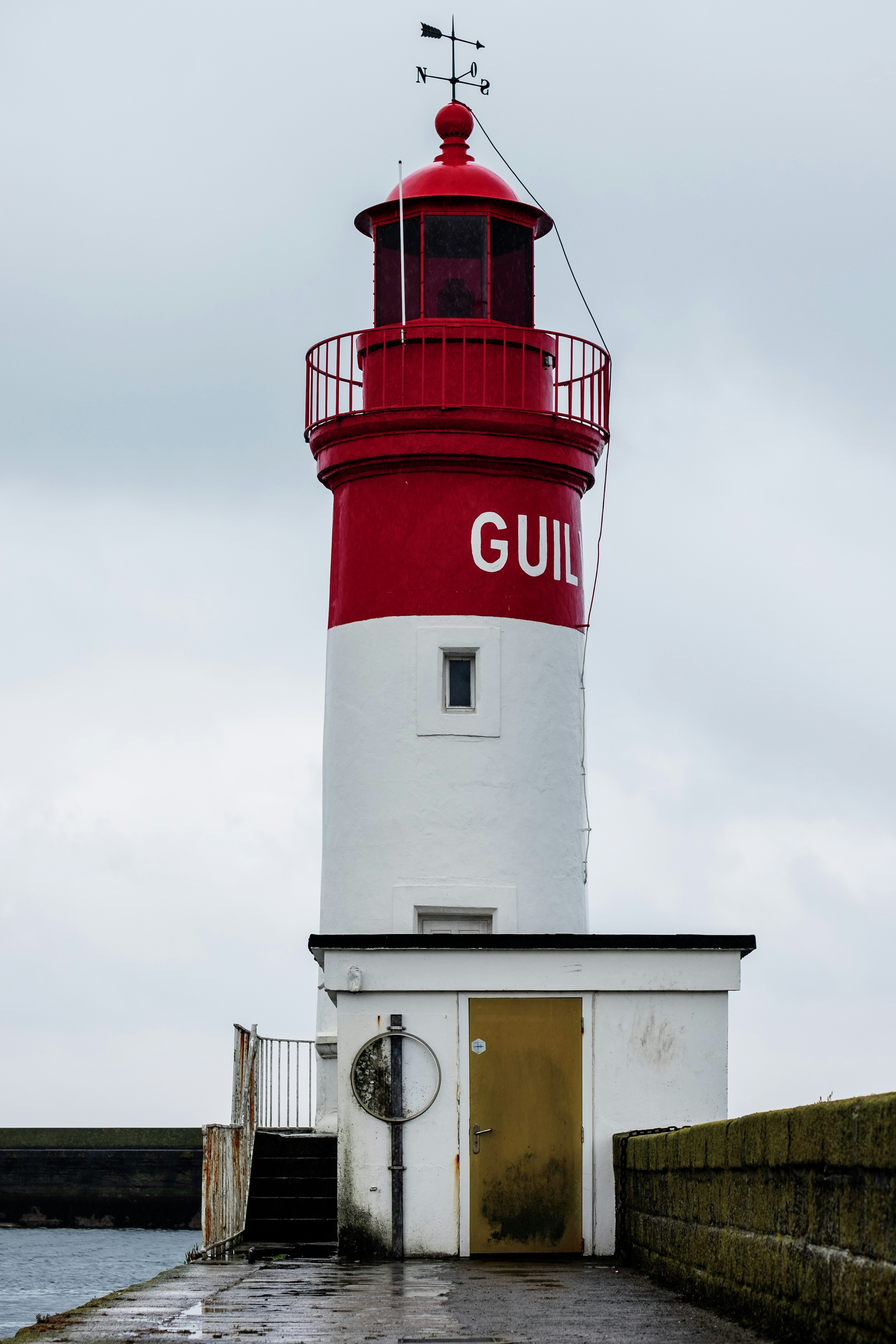 red and white lighthouse under white sky