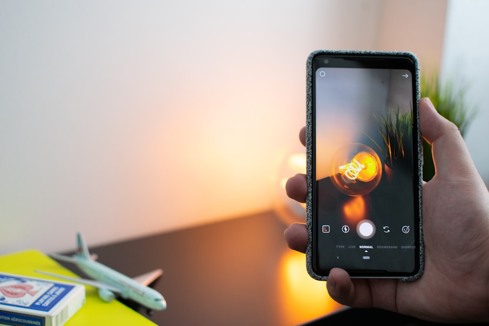 person holding black Android smartphone with brown case