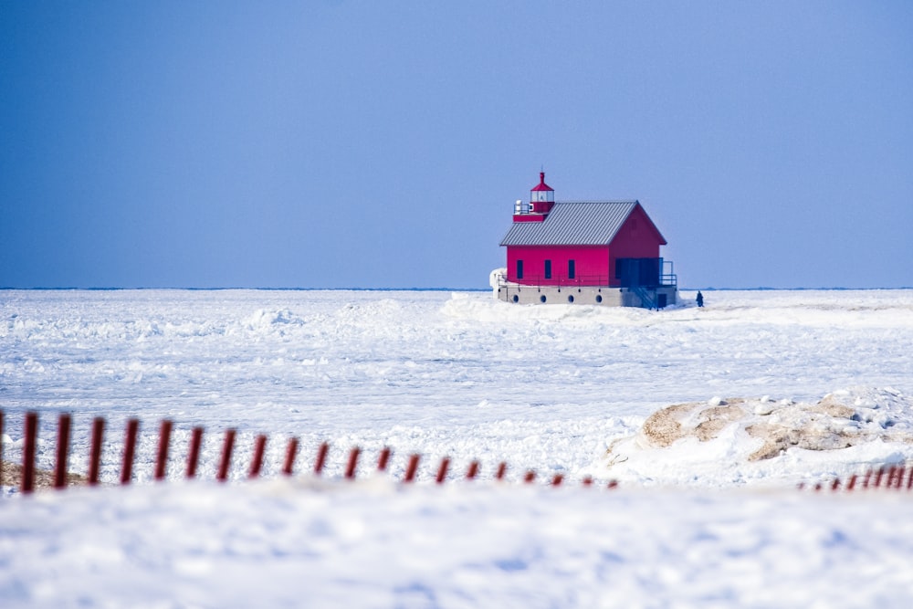 Casa vermelha no campo de neve
