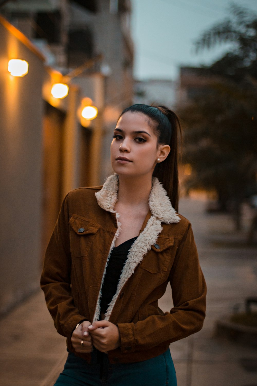 woman holding brown coat during daytime