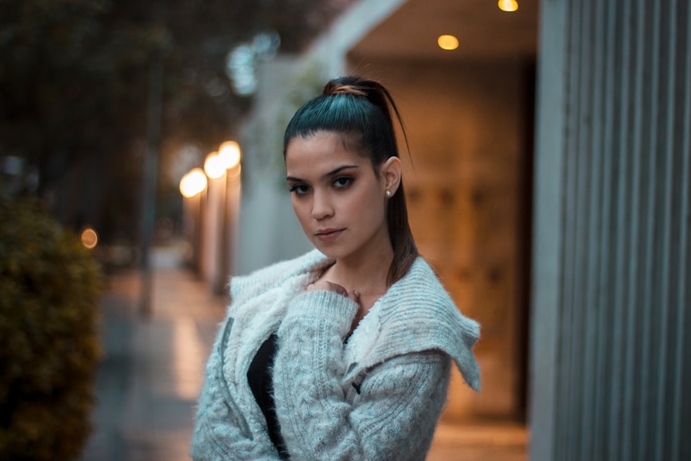 woman in gray coat standing near building