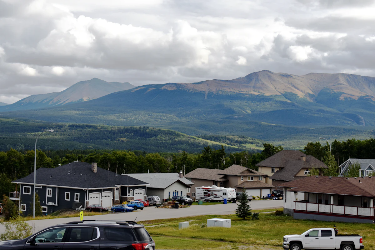 Houses on a street in Grande Cache, with forested ridges and bare mountains behind