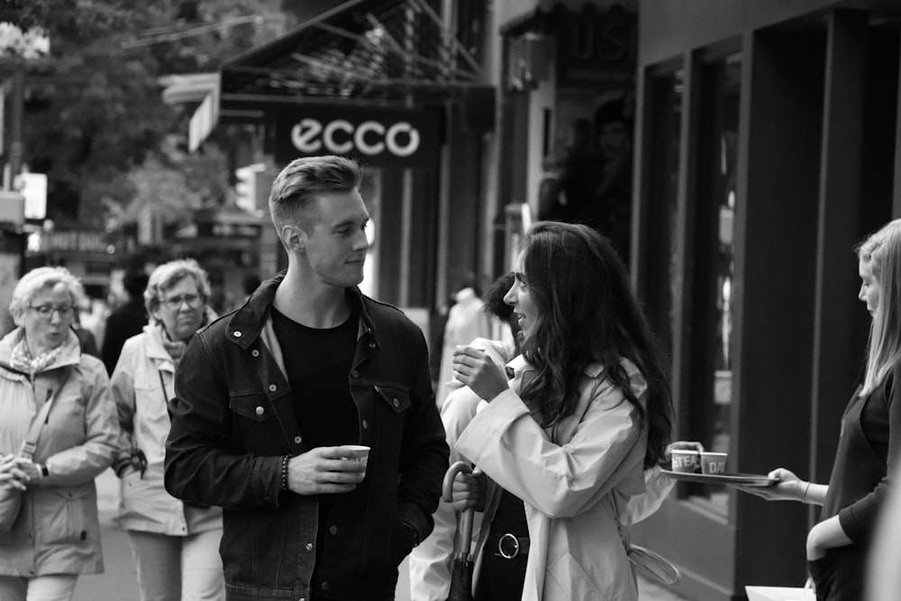 grayscale of woman and man talking each other