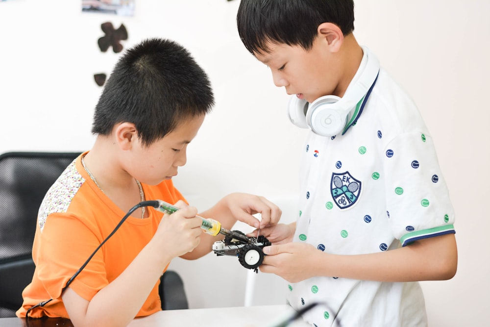 boy soldering car toy white sitting on chair