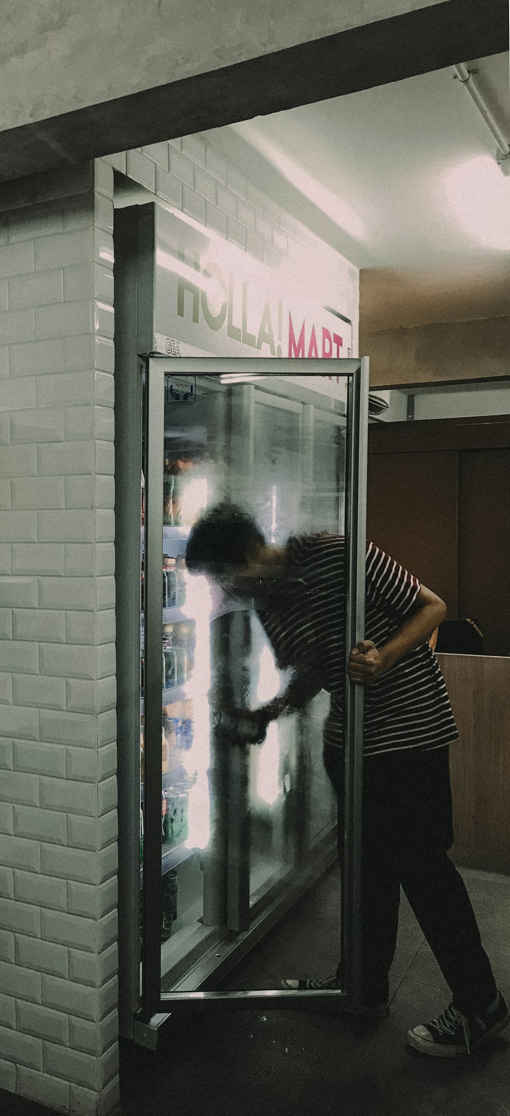 man grabbing drink in fridge