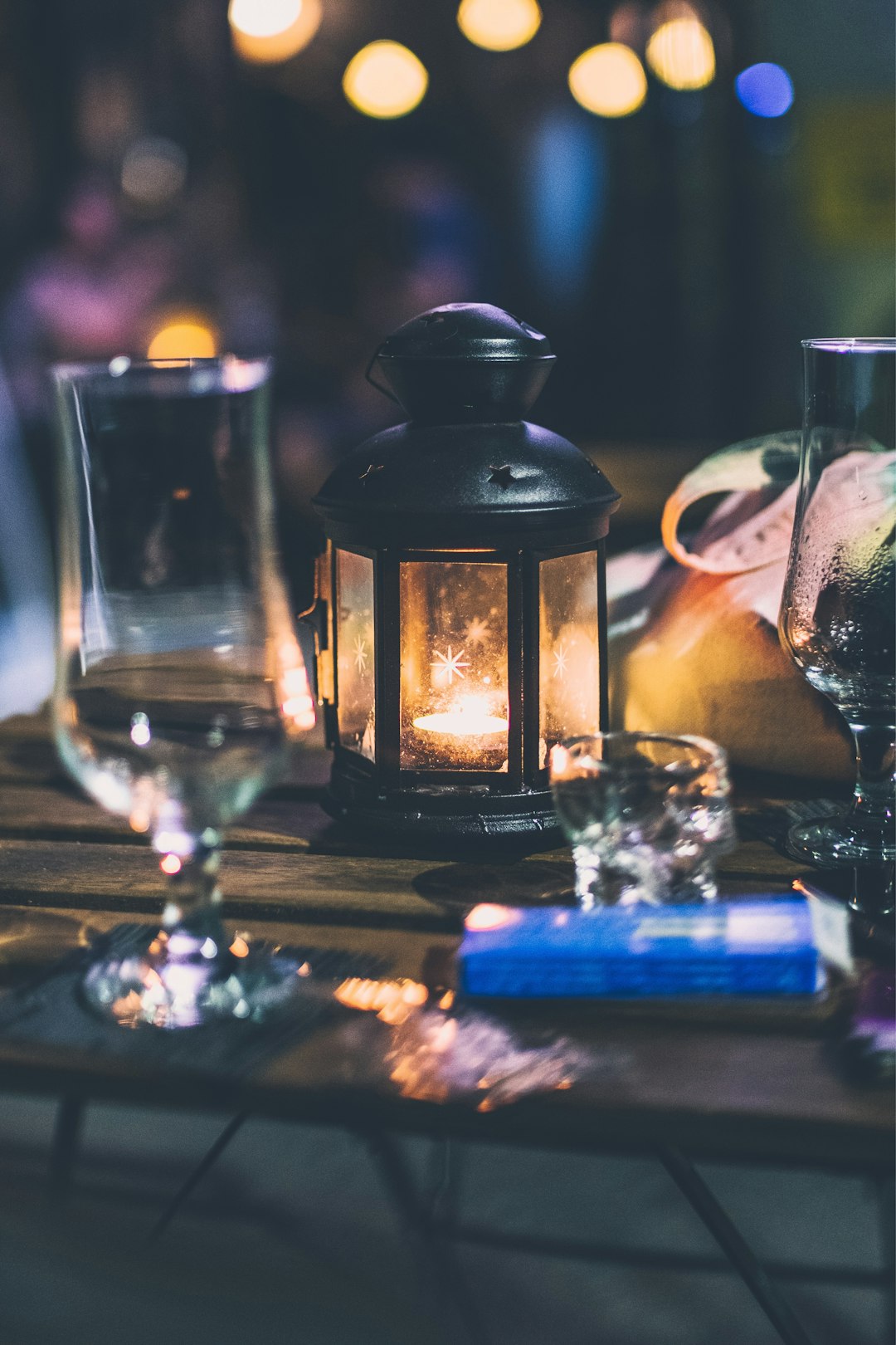 clear wine glass near black candle lantern
