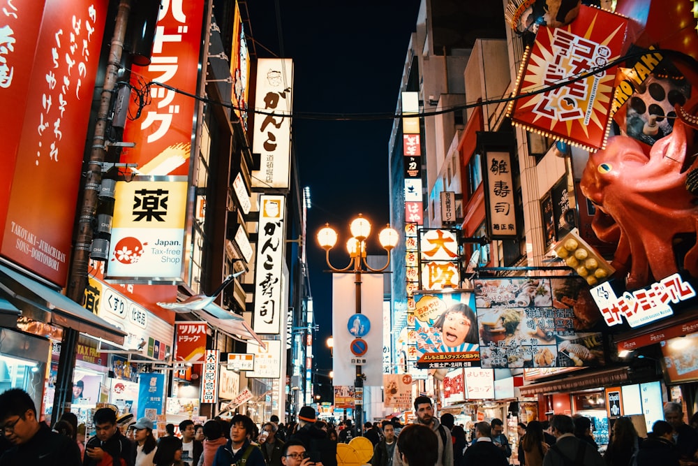 people standing between buildings at night