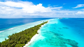 Aerial view of a tropical island with clear blue waters and sandy beaches.