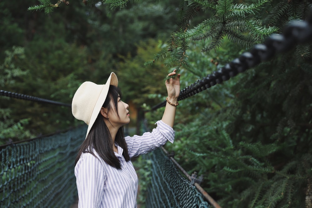 selective focus photography of woman holding green leaf