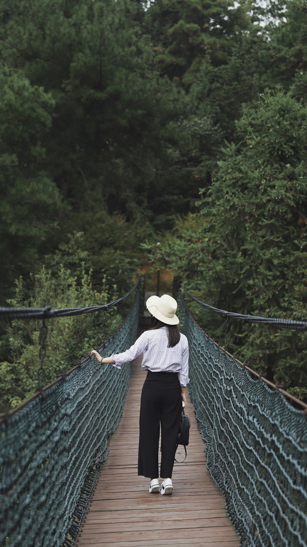 woman standing in between brown and green bridge