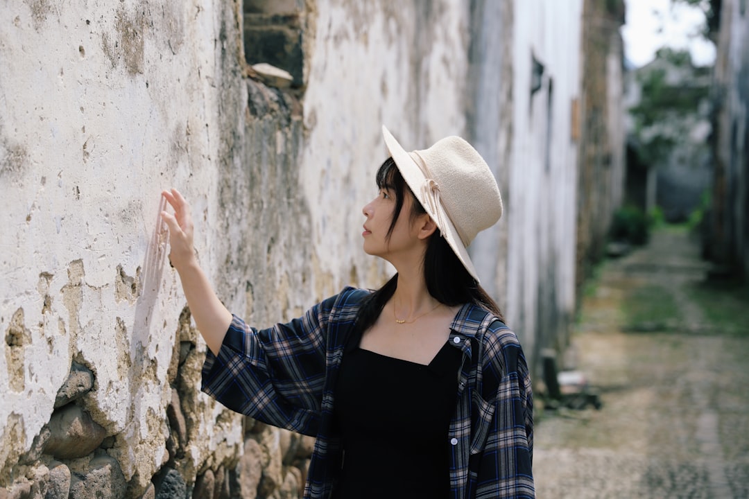 selective focus photography of woman touching wall