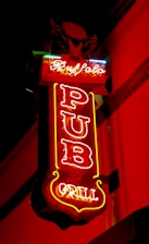 A neon sign with vibrant colors displays the words 'Buffalo Pub and Grill' against a dark background. The sign is predominantly red, with accents of yellow and blue, featuring a stylized image of a buffalo at the top.
