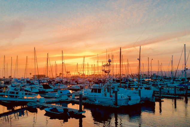 A vibrant marina scene at sunset with sailors preparing their boats, highlighting community and connection.