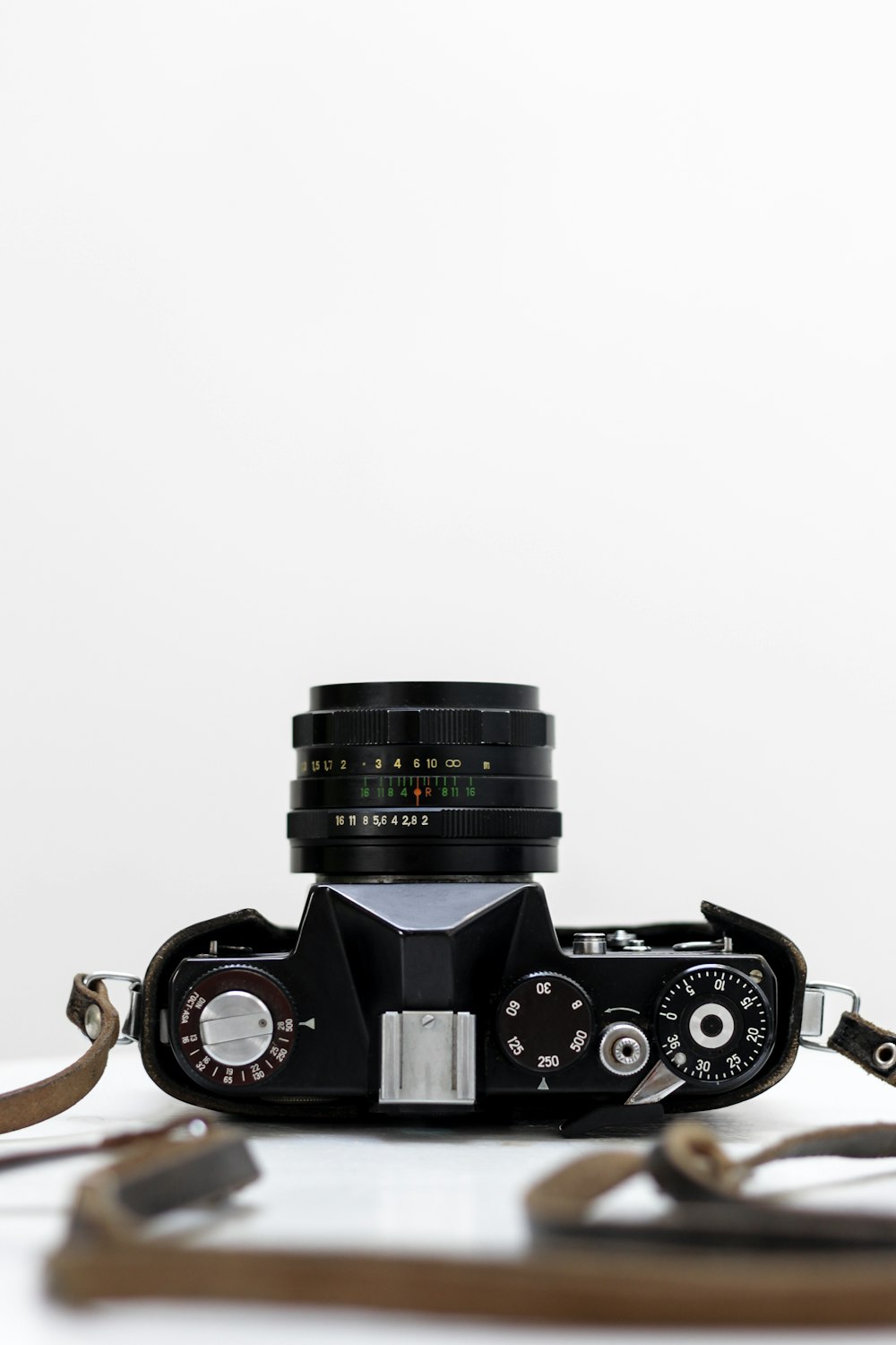 black and grey DSLR camera with white background